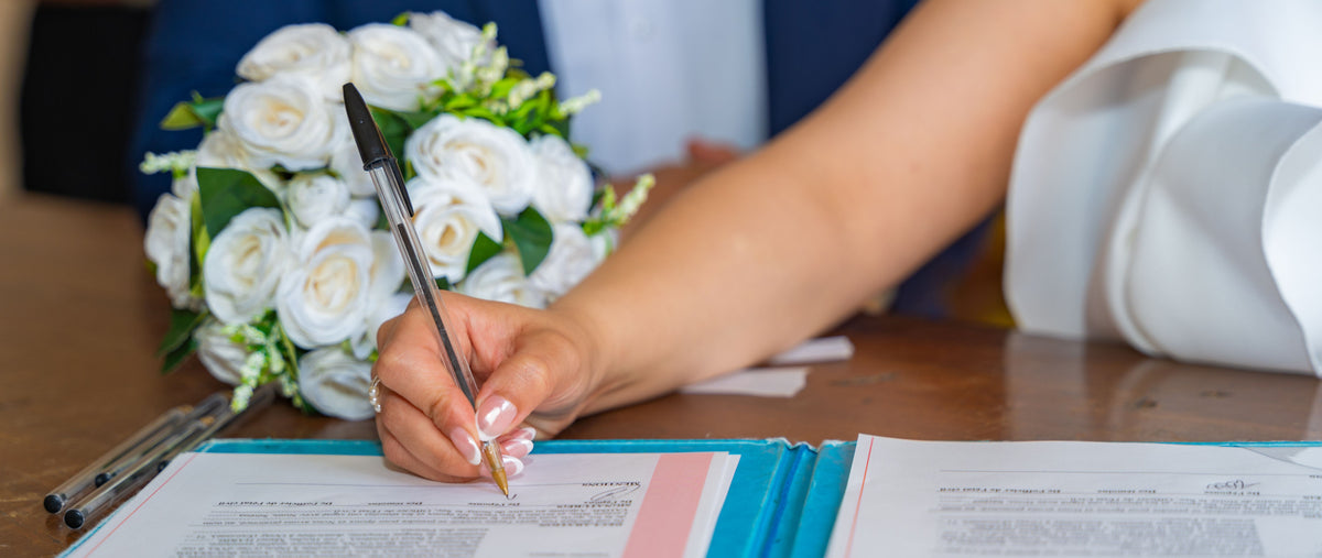 Bride signing her wedding documents with an ordinary pen.