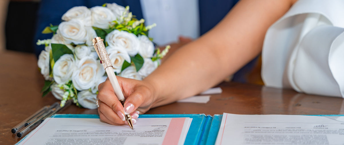 Bride signing her wedding documents with the Wedding Pen.